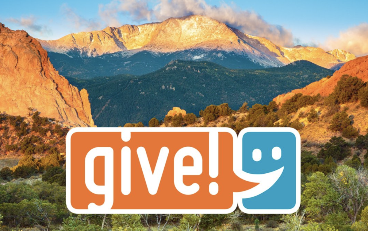 The orange and blue Give! campaign logo over a sunrise view of Pikes Peak and Garden of the Gods